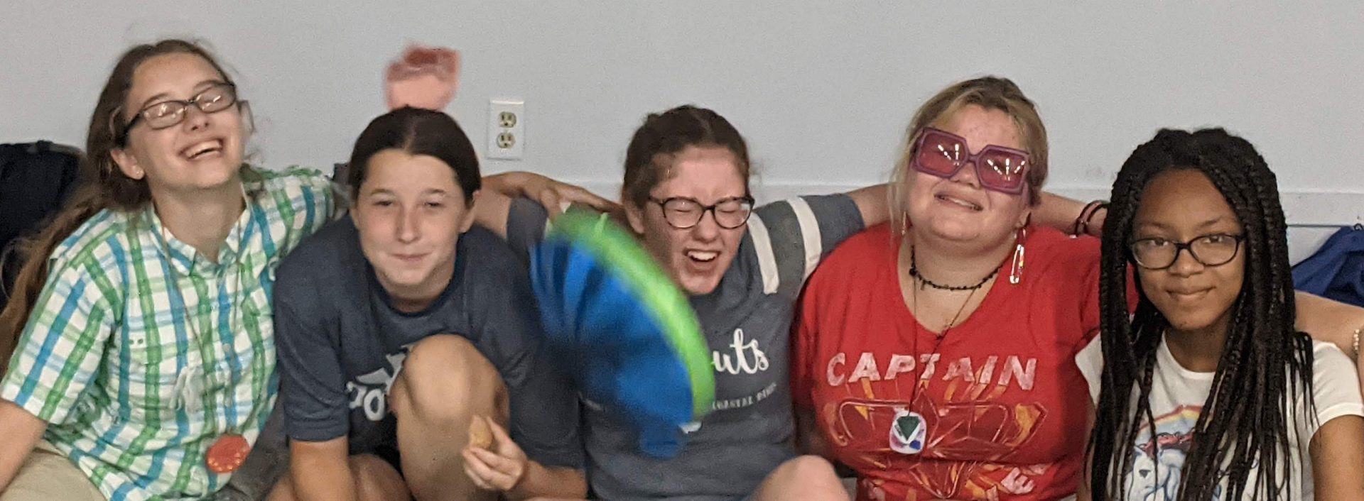  Girls sitting on a couch laughing. 